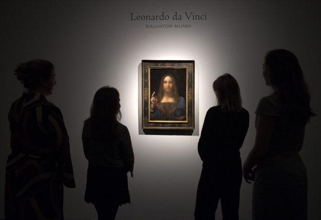 LONDON, ENGLAND - OCTOBER 24: Staff members pose next to a painting by Leonardo da Vinci entitled 'Salvator Mundi' before it is auctioned in New York on November 15, at Christies on October 24, 2017 in London, England. The painting is the last Da Vinci in private hands and is expected to fetch around 100,000,000 USD. (Photo by Carl Court/Getty Images)